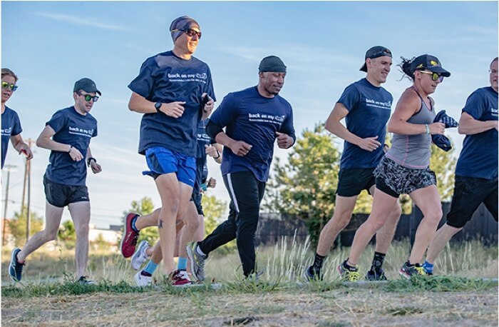 Runners on a grassy trail.