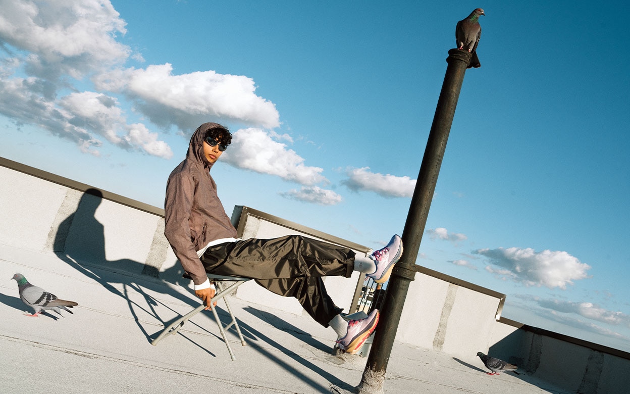A man wearing sunglasses leans back in a chair on a clear blue day
