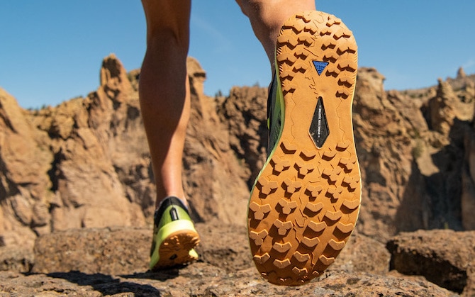 The bottoms of a pair of trail shoes