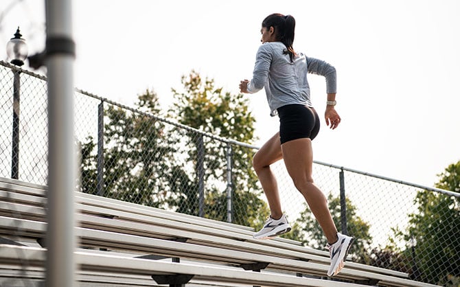 Women running up bleacher steps.