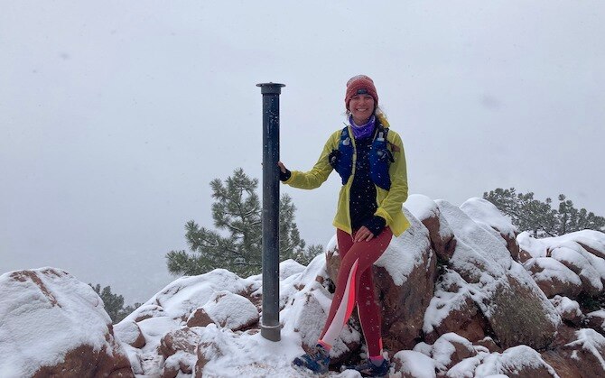 Maggie on top of a snowy mountain