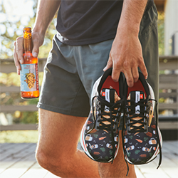 A man holding running shoes with a beer pattern