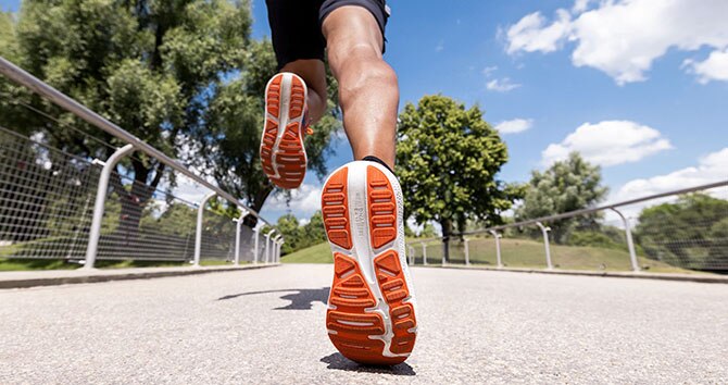 Prise de vue en contre-plongée des chaussures de running Ghost MAX portées lors d’un sprint.