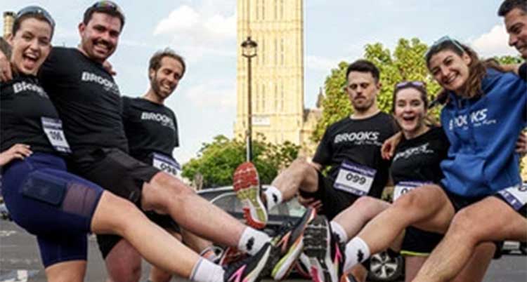 A group of people wearing Brooks pose for a picture.