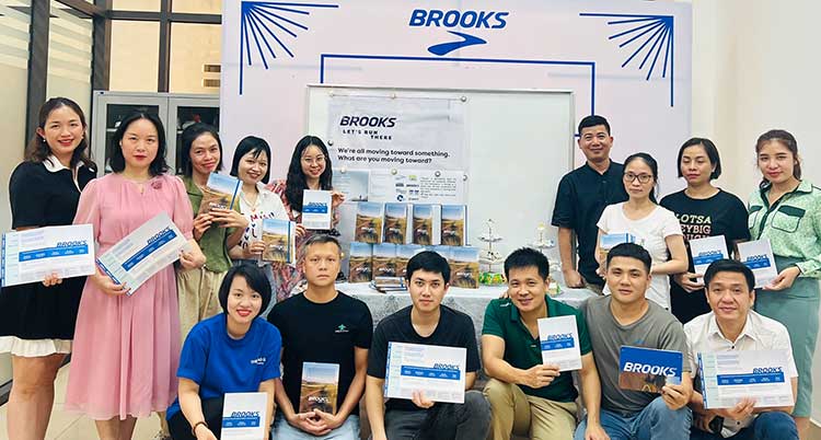 A group of people standing in front of a Brooks sign