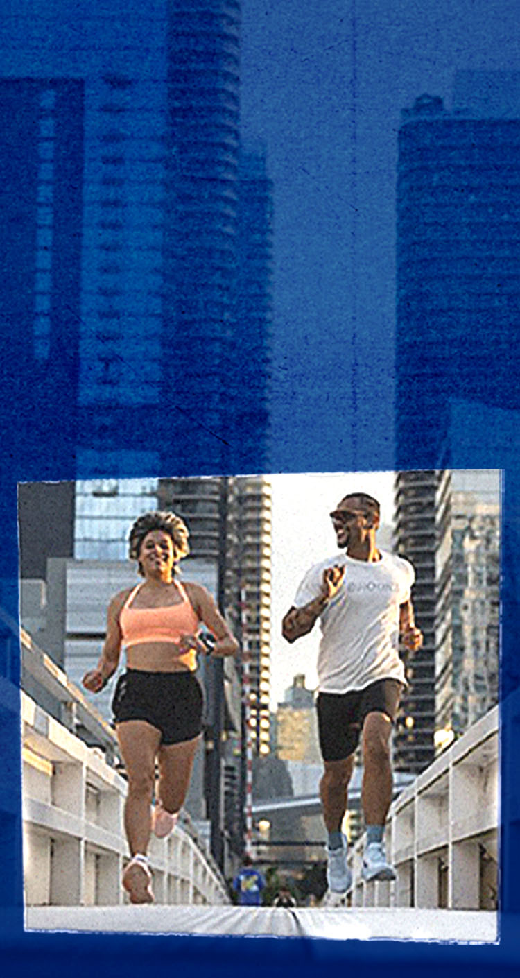 A pair of runners in stride in a city