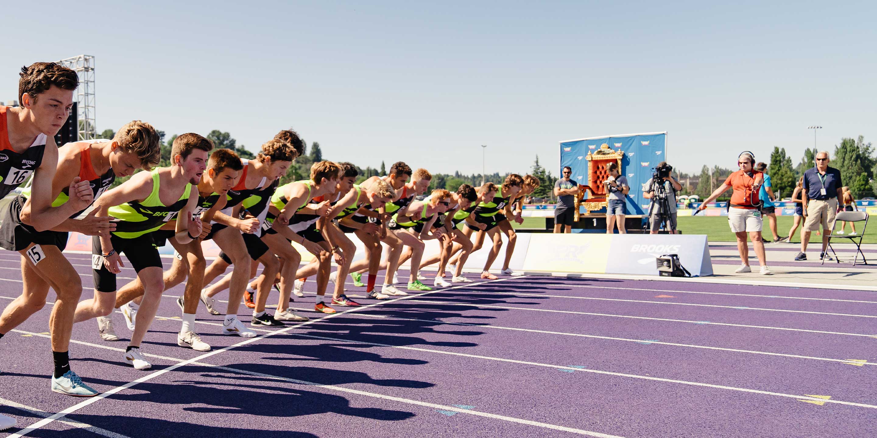 Athletes lined up on the track on a sunny day