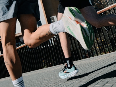 Two people running on a sidewalk
