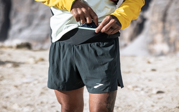 Mezza figura di un uomo che indossa i pantaloncini da trail di Brooks Running