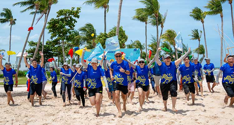 A group of people run on a sandy beach
