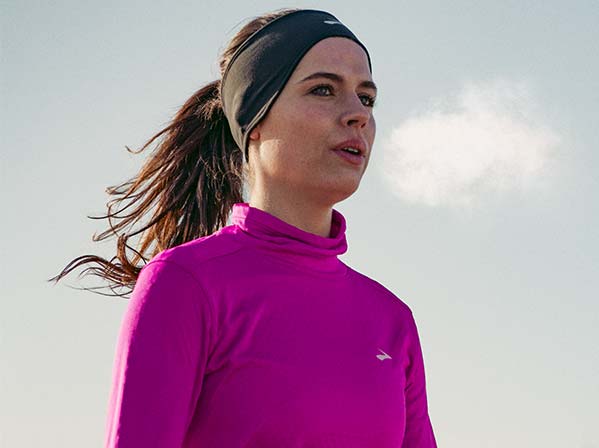 Une femme portant des vêtements Brooks regarde sur le côté