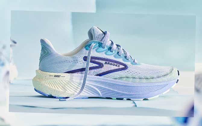 A purple and blue Brooks shoe sits against a light blue background
