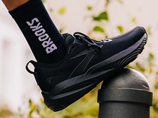 Schwarzer Schuh ruht auf einem Stock