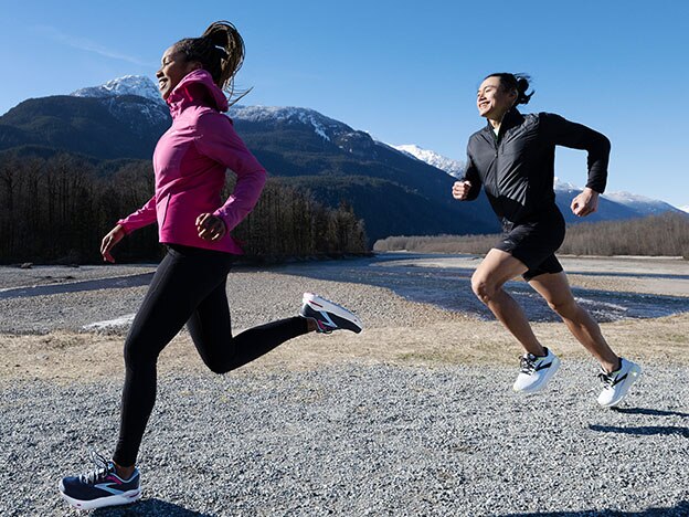 Long shot of a woman and a man wearing Brooks Running clothing on rocky track