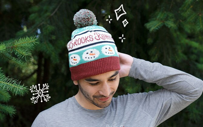 Man wearing beanie cap, while illustrations of snowflakes fall around him.