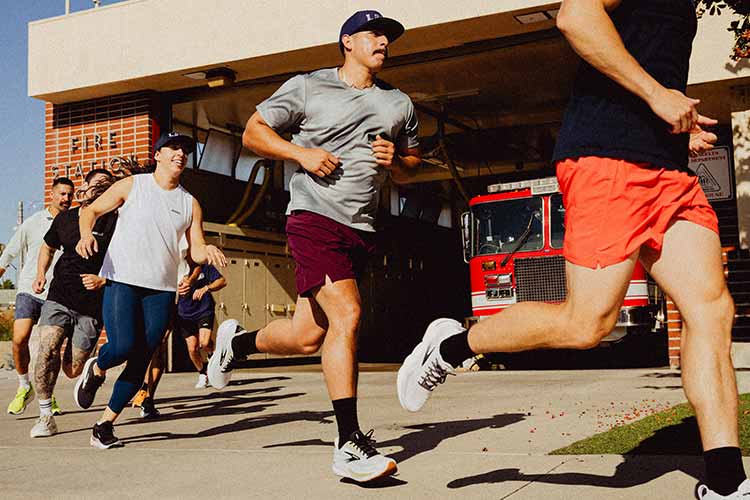 A group of people running outside of a fire station