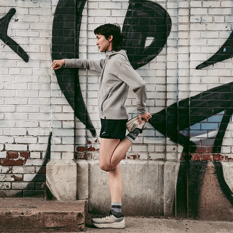 Medium shot of a woman stretching before a run