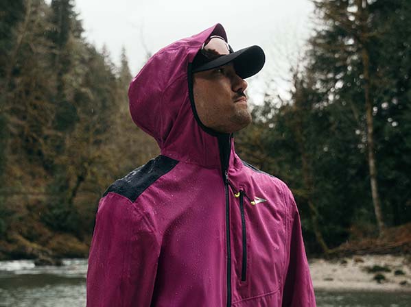 A man wearing Brooks apparel against a natural background