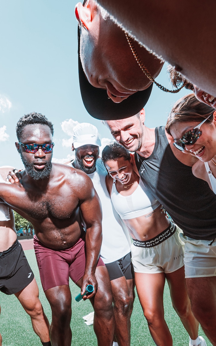 A group of runners gather in a huddle