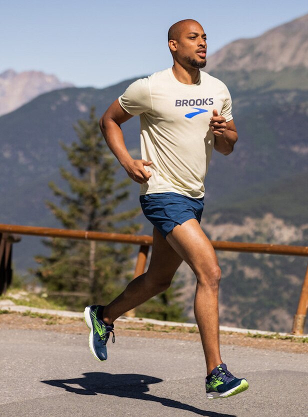 A man running with mountains in background