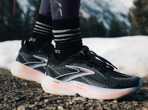 A person wears Brooks women’s shoes in a snowy setting