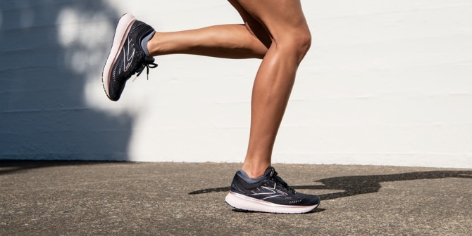 A close-up shot of a woman running outdoors in a pair of black Brooks Glycerin 19 shoes.
