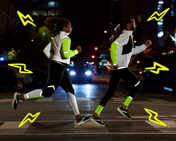 Due runner che corrono di sera indossando la collezione Run Visible