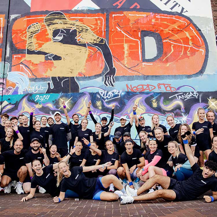 Brooks employees standing in front of a colorful wall.
