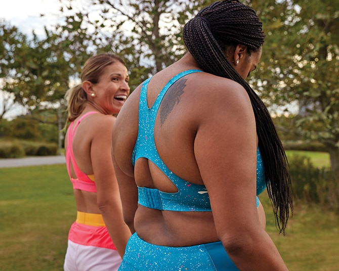 Two women outside wearing pink and blue running apparel