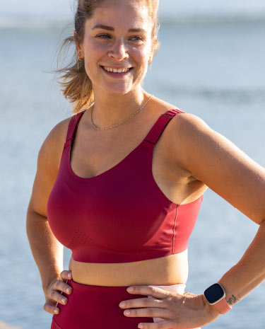 A close-up of a woman in a red Dare Run Bra smiling at the camera.