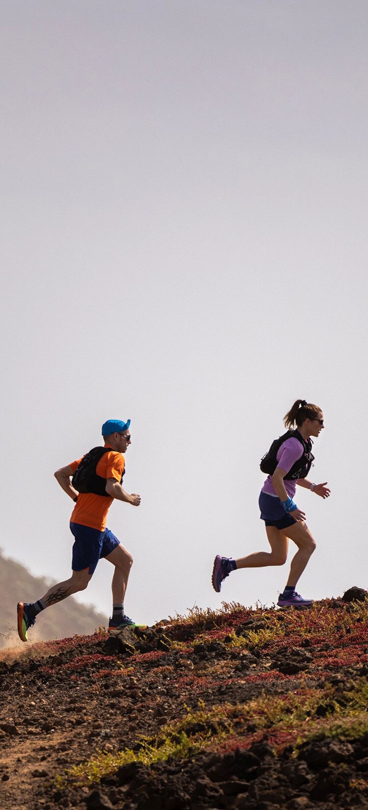 Deux runners Brooks courant sur une colline rocheuse