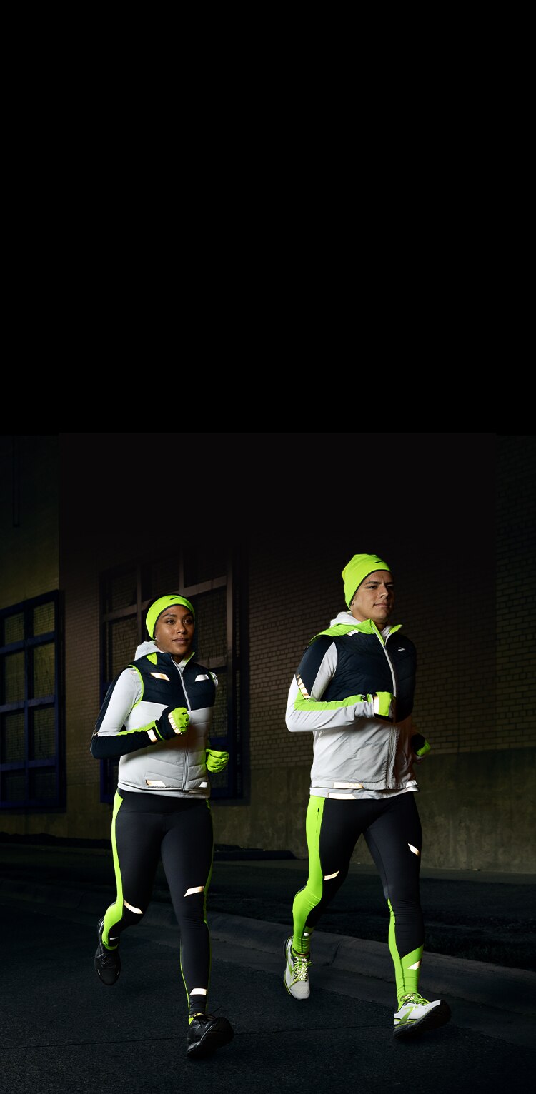 Two runners wearing Brooks reflective running gear in the dark