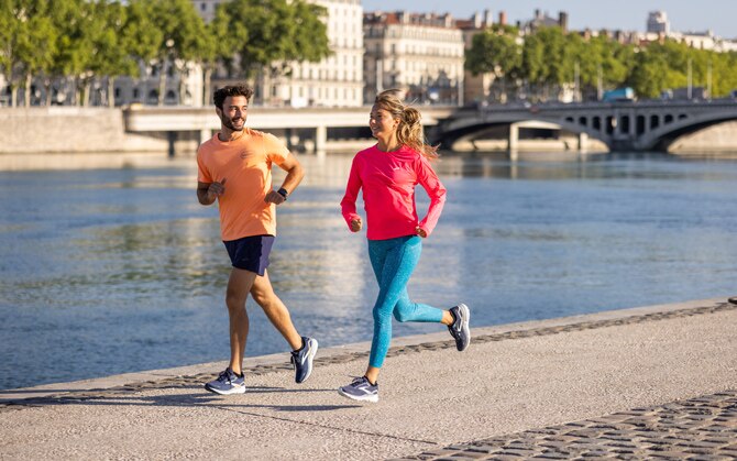 Two runners sprint on a pavement during high-intensity interval training.
