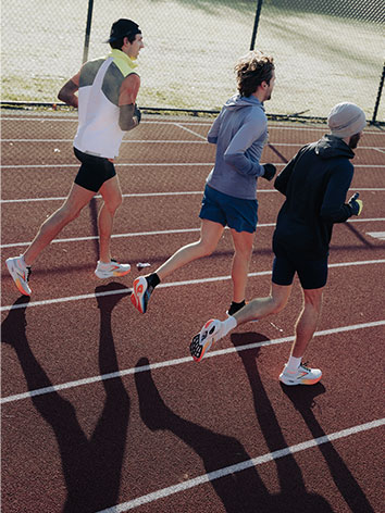 Three people running on a track