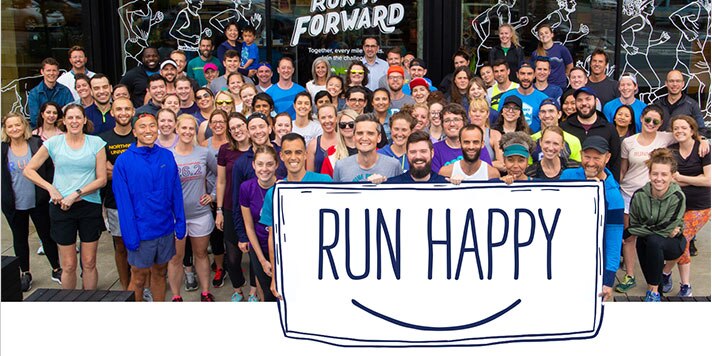 Brooks employees holding a Run happy sign