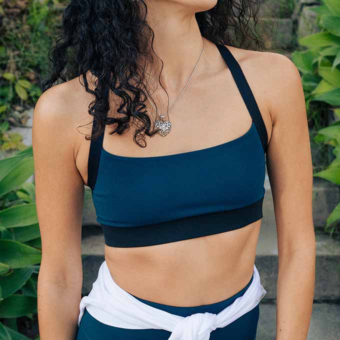 A woman with curly hair wearing the Luxe Strappy Bra.