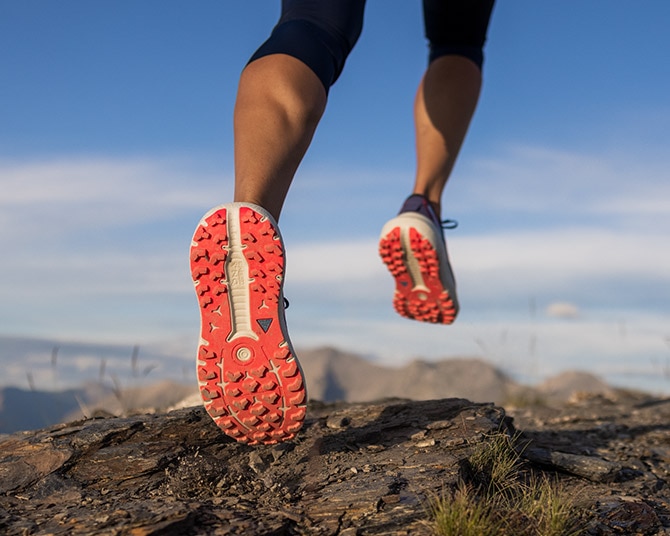 Modella con scarpe Brooks che corre in montagna