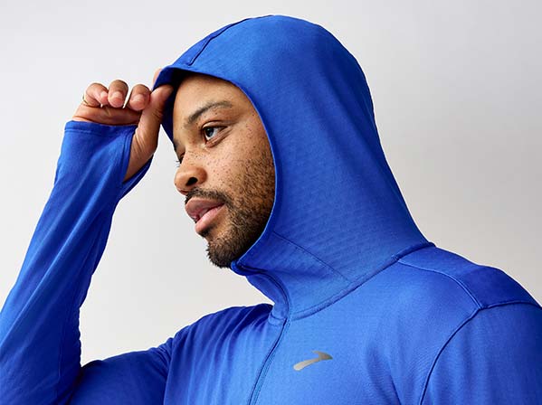 A man wearing Brooks apparel against a white background