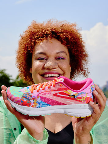 Happy person holding a Run Proud shoe