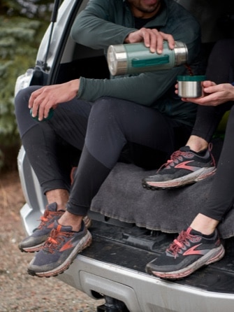 Deux runners assis dans le coffre d’une voiture en portant la Cascadia 16 GTX