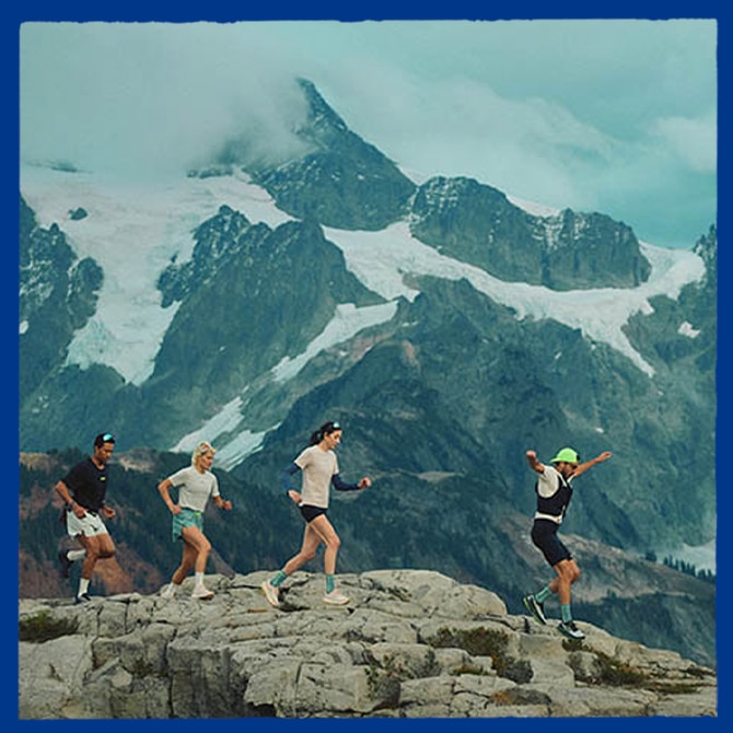 A group of people walk across a rocky mountain