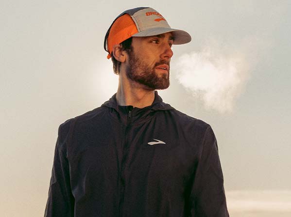 A man wearing Brooks apparel looks to the side