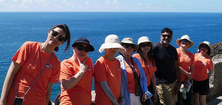 A group of people standing in front of a body of water