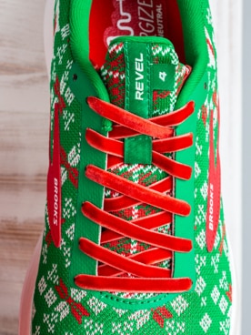 Une chaussure verte avec des lacets rouges sur le dessus