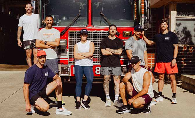 A group of people pose in front of a red fire truck