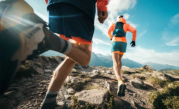 Two people run up a hill