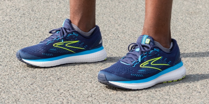 Close-up shot of the man standing in a pair of blue Brooks Glycerin 19 shoes.