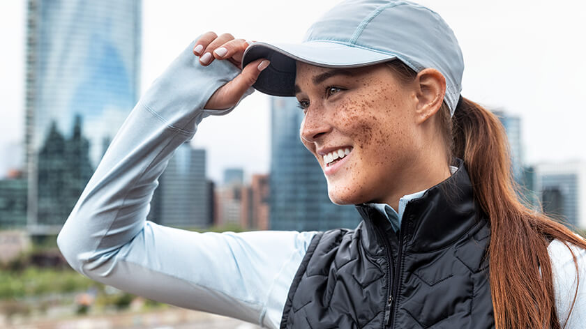 A female runner wears a running cap for lightweight protection from sun and rain.