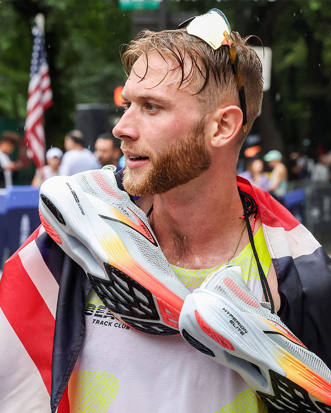 Josh Kerr with Brooks shoes around his neck after a race