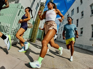 A group of people run outside on a sunny day